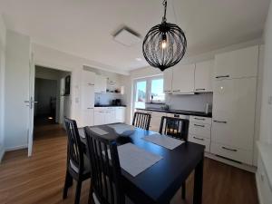 une cuisine et une salle à manger avec une table et des chaises noires dans l'établissement Charmante Ferienwohnung in Tecklenburg, à Tecklembourg 8 autres photos