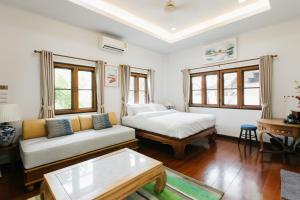 a living room with a bed and a couch at Whisper Oasis - Award-Winning Private Jacuzzi Pool Villa - 3BR, Daily Service in Chiang Mai +80 photos