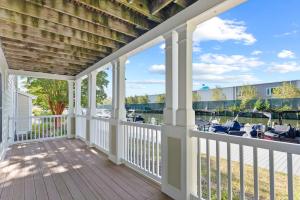 オーシャンシティにある27 Island Edge - Sunset Island Family Luxury Townhomeの白い手すりのあるポーチと椅子のあるデッキ