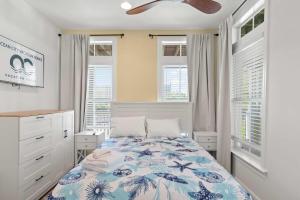 オーシャンシティにある27 Island Edge - Sunset Island Family Luxury Townhomeのベッドと天井扇風機のある寝室