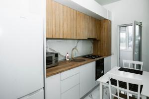 a kitchen with white cabinets and a counter with a microwave at Escape Studio 4 Pollux Militari in Chiajna