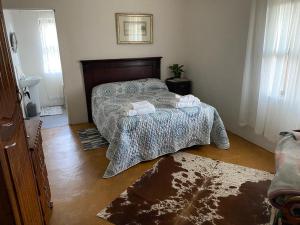 a bedroom with a bed with a comforter and towels at Kareepoort Guest Farm in Bloemfontein