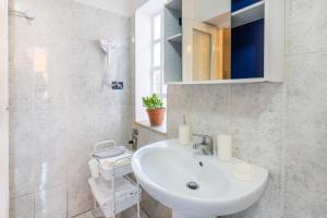 a white bathroom with a sink and a mirror at Zen Jacuzzi Retreat mit Terrasse Garage und 24 7 Check in Netflix und Disney Plus in Casale Monferrato