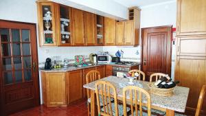 a kitchen with wooden cabinets and a table with chairs at Casa Quinta da Adega do Chão - Vale do Douro in Lamego