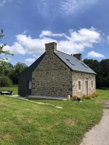 un edificio in mattoni con un tetto nero su un campo di Maison Yvonne 