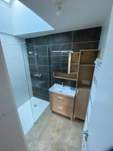 un bagno con doccia, lavandino e specchio di Maison Yvonne 