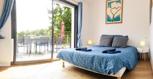 a bedroom with a bed and a sliding glass door at Maison de Saint-Jean in Fouesnant +64 photos