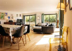 a living room with a table and a couch at Maison de Saint-Jean in Fouesnant
