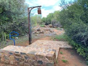 a stone patio with a light hanging over it at Kareepoort Guest Farm in Bloemfontein +6 photos