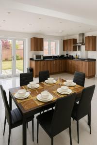 ein Esstisch mit Stühlen und eine Küche in der Unterkunft Harry Potter Stay with Watford & London Links - Family house in Abbots Langley + 6 Fotos