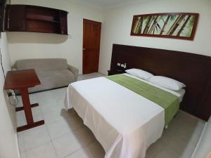 a hotel room with a bed and a couch at Hotel Paseo Colon in Barranquilla