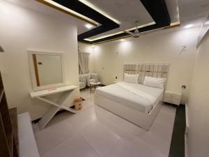una camera da letto con un letto bianco e uno specchio di Comfort Suites Karachi a Karachi