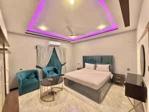 una camera da letto con un letto e una sedia blu di Comfort Suites Karachi a Karachi