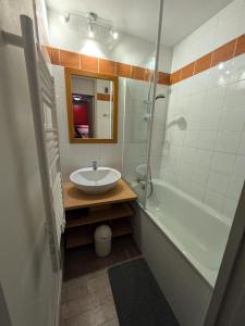 a bathroom with a sink and a tub and a mirror at Résidence Plagne Lauze - maeva Home - Studio 4 personnes - Sélection MAE-1793 in Plagne 1800