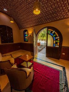 a living room with a table and chairs and a stained glass door at El Juneina Villas in Luxor