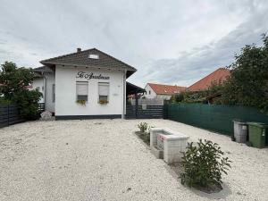 a white building with a sign on the side of it at Tó Apartman in Hegykő