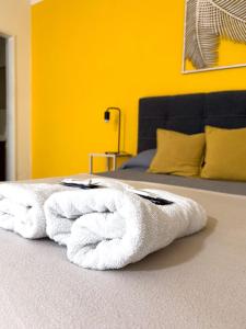 a pile of white towels sitting on a bed at Departamento El Olivo con cochera in Santa Rosa