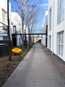 a walkway between two buildings with a yellow boat on the side at Departamento El Olivo con cochera in Santa Rosa
