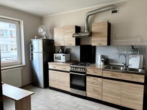a kitchen with a refrigerator and a stove top oven at Kamienica pod Rakiem in Żmigród
