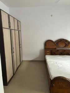a bedroom with a bed and a large wooden cabinet at MOTA HOUSe in Jāmb