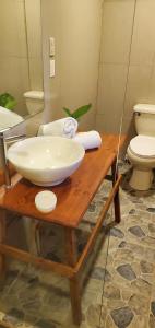 a bathroom with a bowl sink and a toilet at Willy's Fish Camp Hillside Sea View Rooms in Drake