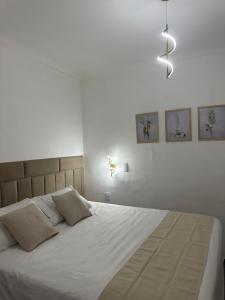 una camera da letto con un letto grande con lenzuola bianche di Via Venetto Feirinha Beira Mar a Fortaleza
