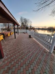 a brick patio with a white fence and a table at Cabana Lir in Arad