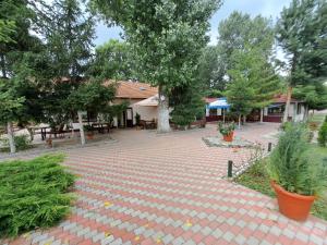 a brick courtyard with trees and a building at Cabana Lir in Arad