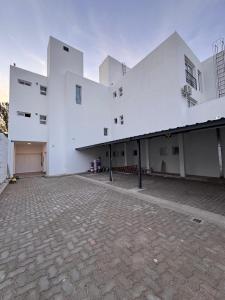 Un gran edificio blanco con un patio de ladrillo. en MonoambienteXdia, en Villa Dolores