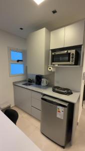 Una pequeña cocina con estufa y microondas. en MonoambienteXdia, en Villa Dolores