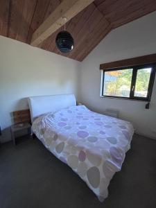 a bedroom with a bed in a room with a window at Le Chalet des Iris in Saint-Maurice-de-Gourdans +17 photos