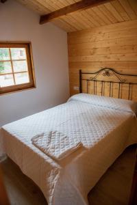 a bedroom with a white bed with a wooden ceiling at Casa Tita Mari in Jaén +11 photos