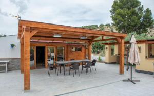a wooden pavilion with a table and chairs at Casa Tita Mari in Jaén