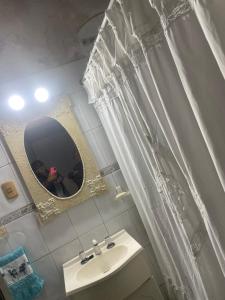 a white bathroom with a sink and a mirror at Antonia in San Nicolás de los Arroyos +4 photos