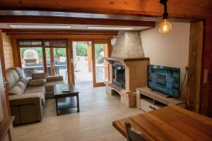 a living room with a tv and a couch and a fireplace at Casa Tita Mari in Jaén