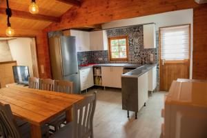 a kitchen with a wooden table and a refrigerator at Casa Tita Mari in Jaén