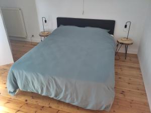 a bedroom with a large white bed with two tables at Les Trois-Escabelles in Dinant +23 photos