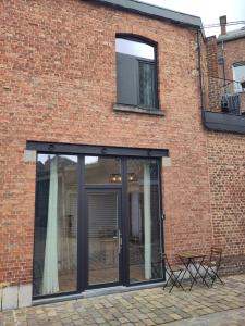 a brick building with sliding glass doors on it at Les Trois-Escabelles in Dinant +23 photos
