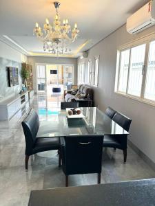 ein Esszimmer mit einem Glastisch und schwarzen Stühlen in der Unterkunft Casa dos sonhos na Zona Sul in Ribeirão Preto