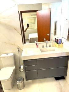 ein Badezimmer mit Waschbecken, Spiegel und Toilette in der Unterkunft Casa dos sonhos na Zona Sul in Ribeirão Preto + 20 Fotos