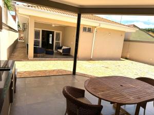 eine Terrasse mit einem Tisch und Stühlen auf einer Terrasse in der Unterkunft Casa dos sonhos na Zona Sul in Ribeirão Preto