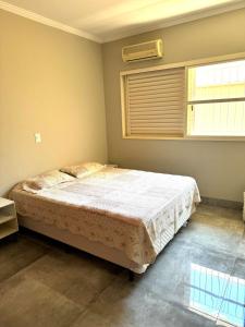 1 Schlafzimmer mit einem Bett und Klimaanlage in der Unterkunft Casa dos sonhos na Zona Sul in Ribeirão Preto