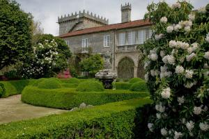 une maison avec un jardin planté de buissons et de fleurs dans l'établissement A Casa de Salvador - retiro rural con alma gallega, à Vedra
