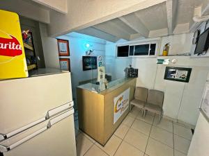 a small kitchen with a counter and a refrigerator at Hotel C Villa Plaza in San Gil