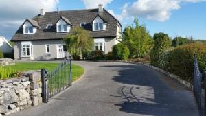 una casa blanca con valla y entrada en Cuileann, en Clarinbridge