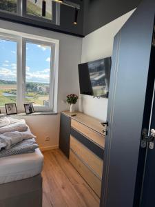 Un dormitorio con una cama y un televisor y una ventana. en Sapore Dream STUDIO 4, en Opole