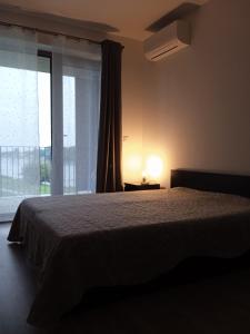 a bedroom with a bed and a large window at Apartmany BlueWave Riverside Piešťany in Banka +24 photos