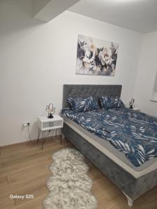 ブルチコにあるModern Apartment MOMENTのベッドとナイトスタンド付きのテーブルがある寝室