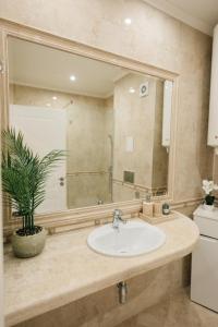 a bathroom with a sink and a large mirror at Grand Karavel - Luxury Central 1BR + Parking in Varna City +27 photos