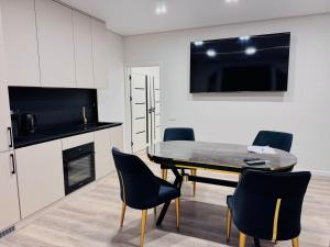 een keuken en eetkamer met een tafel en stoelen bij Royal Boulevard Terrace Residence in Chişinău